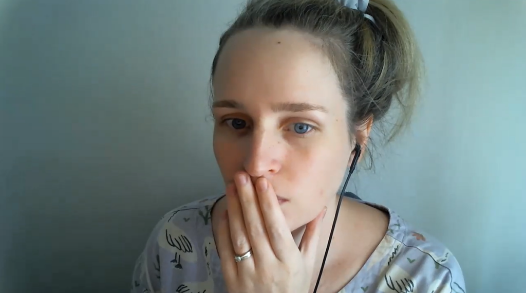 Woman with black earphones waiting for client to join Zoom call.